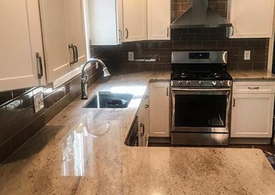 White kitchen cabinets with custom natural stone granite countertop by Gordon Creek Granite of Hicksville, Ohio.