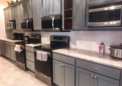 Gray kitchen cabinets with custom natural stone granite countertops by Gordon Creek Granite of Hicksville, Ohio.