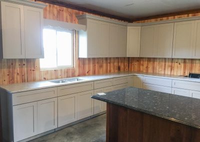 White kitchen cabinets with custom natural stone countertops by Gordon Creek Granite of Hicksville, Ohio.